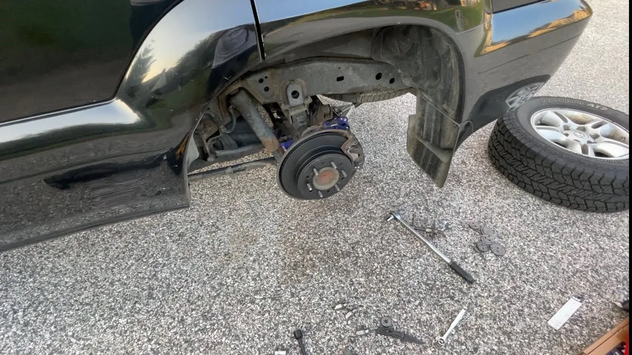 Mobile tire change on a black SUV in a gravel driveway in Alta Vista, Ottawa