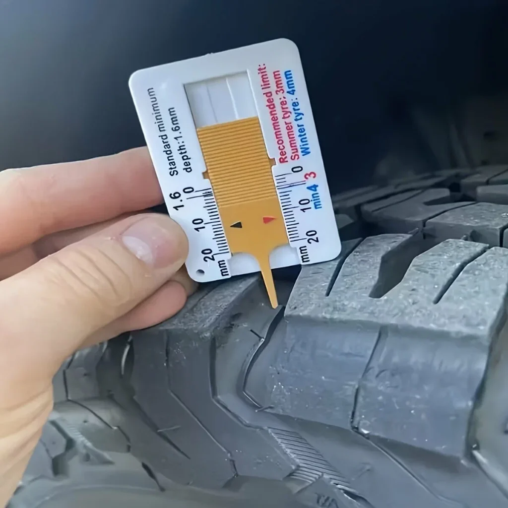 Tread depth gauge measuring the main groove of a winter tire before a seasonal tire change in Ottawa